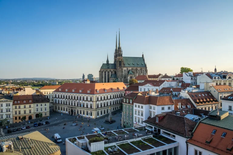 Elevated view over Brno's old town, with the twin Gothic spires of the Cathedral of St Peter and Paul rising above the rooftops.