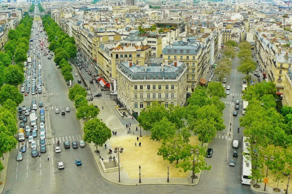 Aerial view of Paris showing tree-lined Haussmann boulevards radiating from a central square
