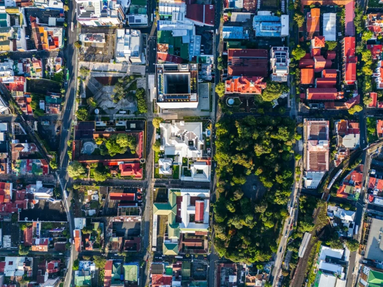 Aerial top-down view of a San José neighbourhood in Costa Rica's Central Valley, with a tree-filled park beside the street grid.