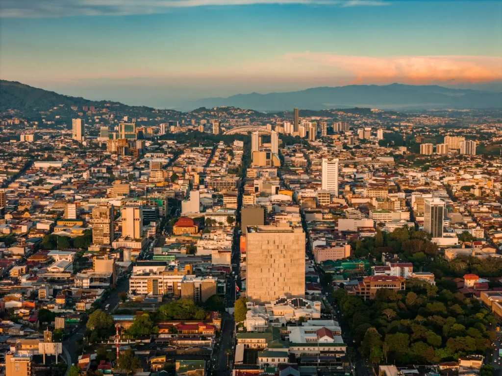 Aerial view of San José, Costa Rica at sunrise, the city spread across the Central Valley below the mountains.