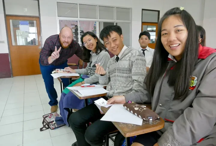 TEFL trainee with Thai students during teaching practice in a classroom in Chiang Mai, Thailand